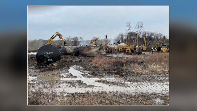 Contractors at the East Palestine, Ohio train derailment site removing a burned tank car during cleanup operations.