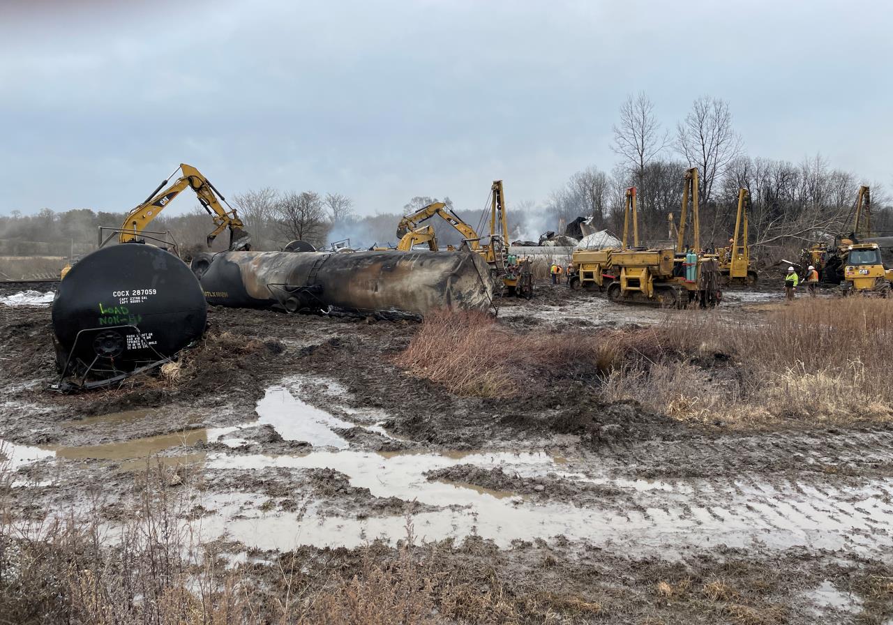 Contractors at the East Palestine, Ohio train derailment site removing a burned tank car during cleanup operations.
