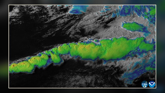 Satellite/remote-sensing image showing a line of severe thunderstorms firing up across the Midwest, with large convective towers and cloud structures indicative of severe weather.