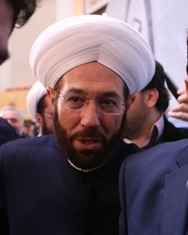 Portrait of Ahmad Badreddin Hassoun, former Syrian grand mufti, at the International Islamic Unity Conference (decoration/venue background).