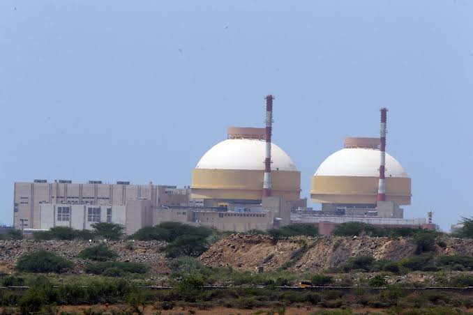 A clear, creditable exterior shot of the Kudankulam nuclear power plant (or a generic coastal nuclear plant if location photo is unavailable) overlaid with a neutral ‘data’ icon. The image should avoid implying a safety incident or damage; focus on the site and the abstract concept of a data exposure.
